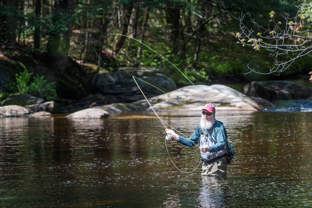 man in river fly fishing