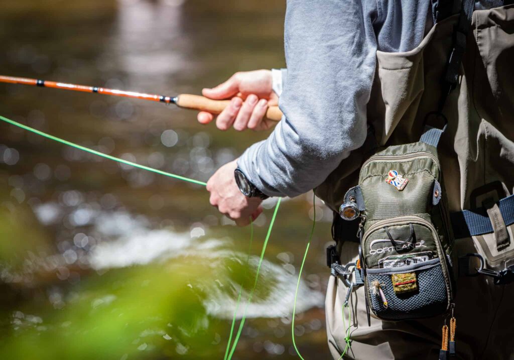 Man fly fishing in river in Maine - Stonetree Creative