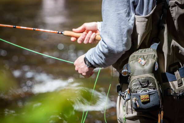 Man fly fishing in river in Maine - Stonetree Creative