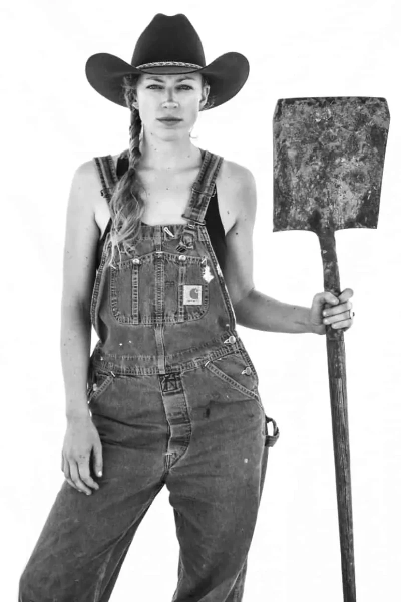 woman wearing cowboy hat holding shovel