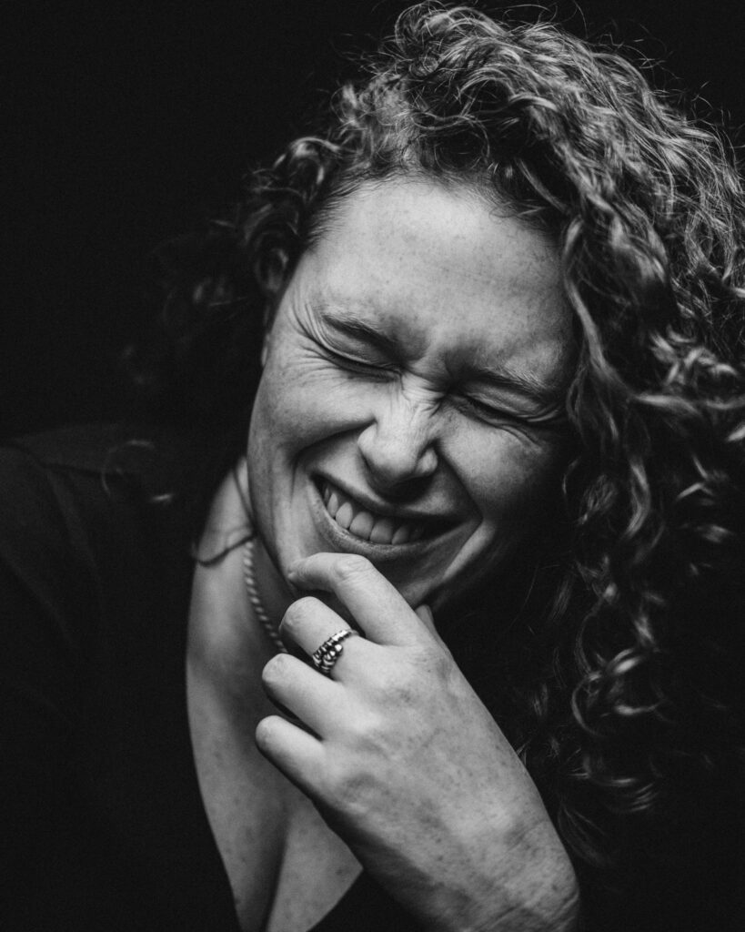 woman with curly hair laughing black and white